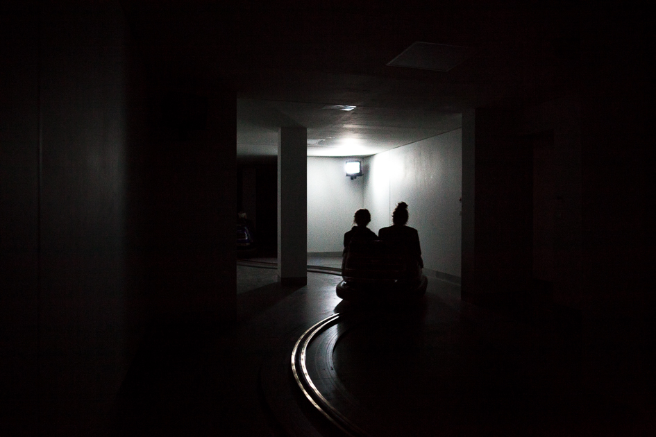 Two people in a bumper car in the dark. 