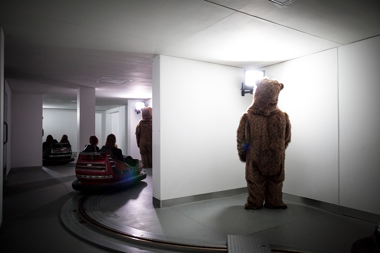 Bumper cars drivign around bears watching TV. 