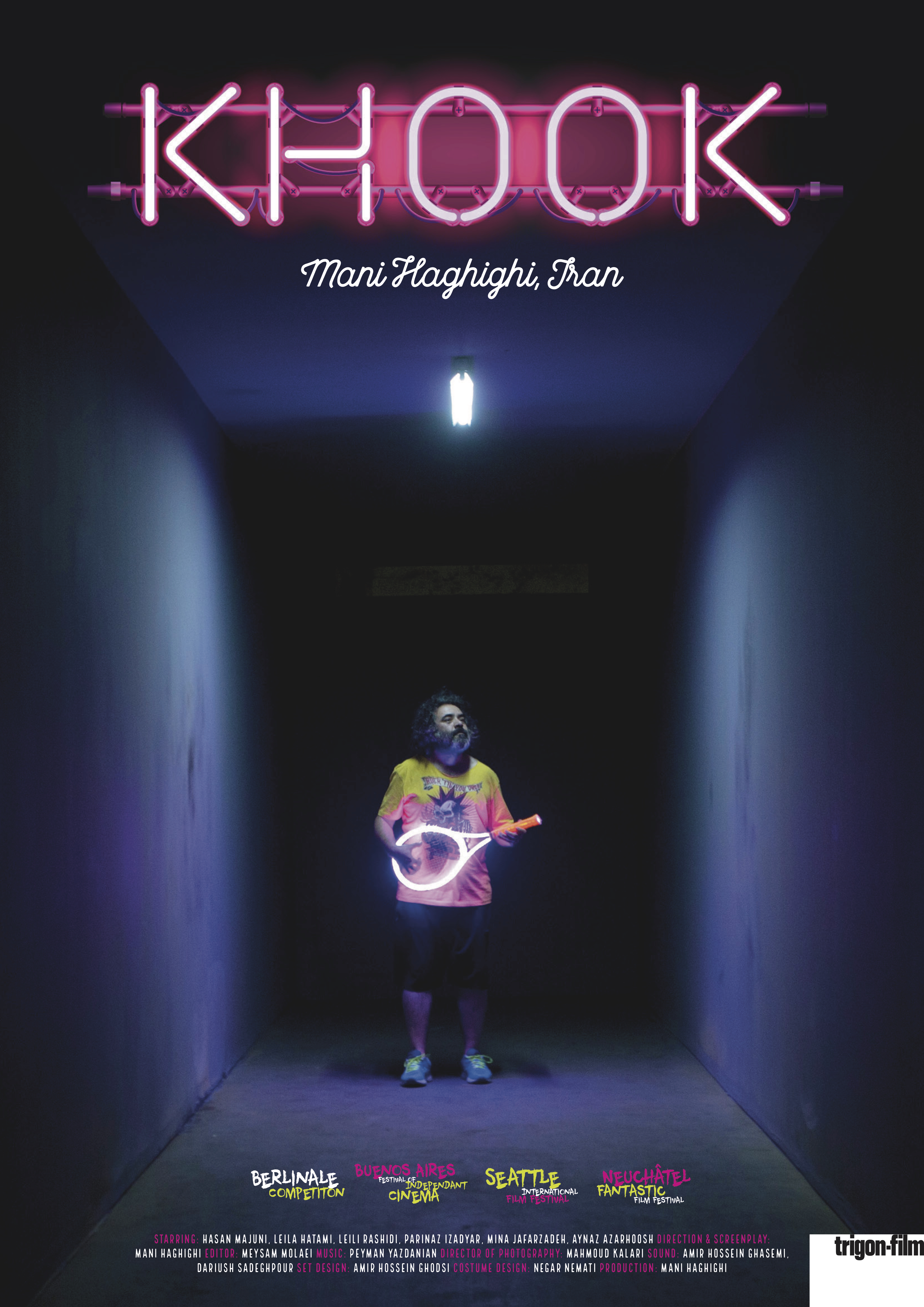 The film poster showing Hasan Majuni in a colorful outfit standing in a dark corridor.