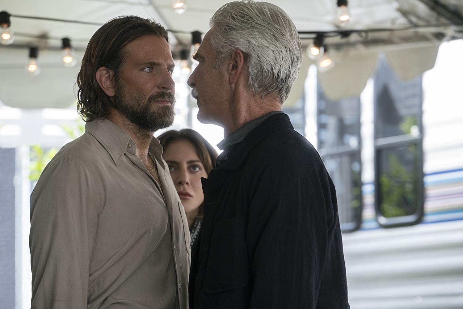 Jack (Bradley Cooper) facing his brother Bobby (Sam Elliott), with Ally (Lady Gaga watching in the background.