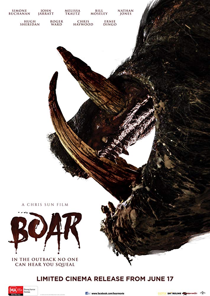 The film poster showing a boar head with an open mouth and massive fangs in profile.