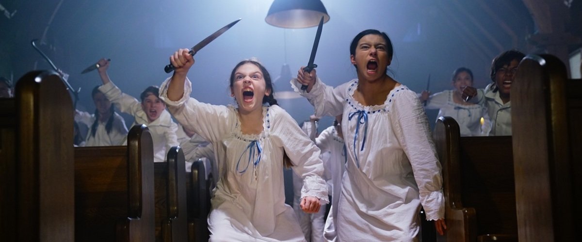 Two girls with raised knives running towards the camera.