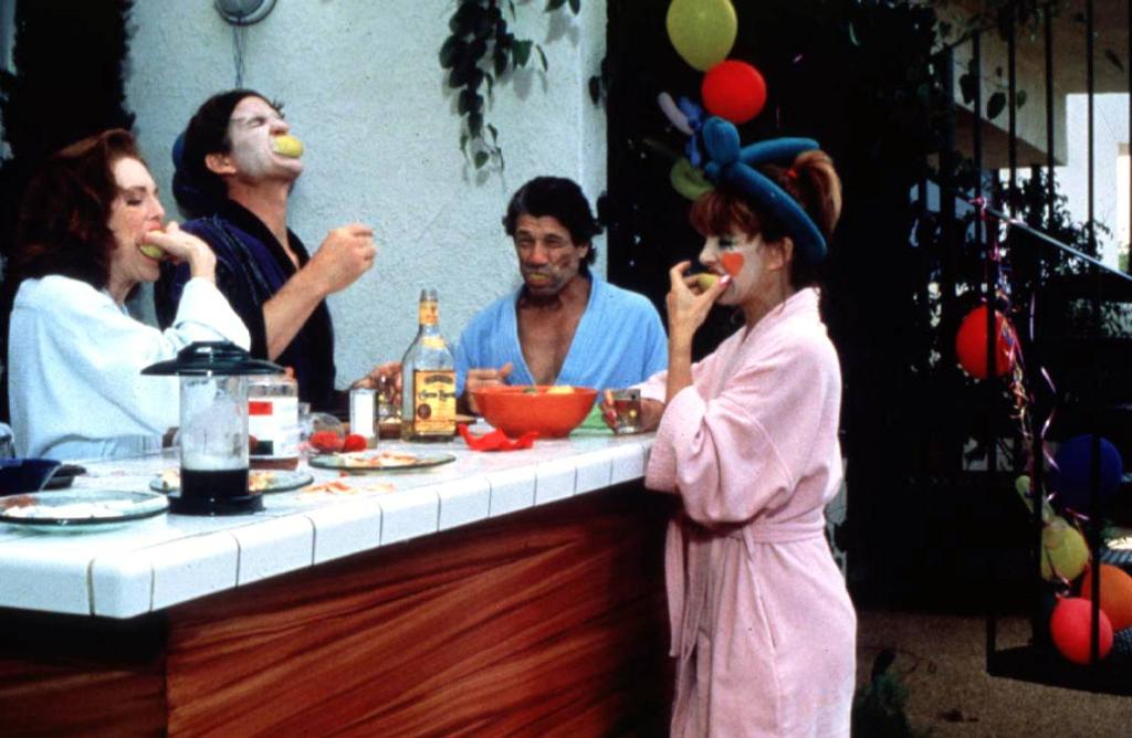 Two couples partly in clown make-up doing shots.