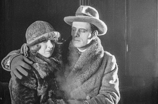 A young man hugs a young woman, both have worried expressions. 