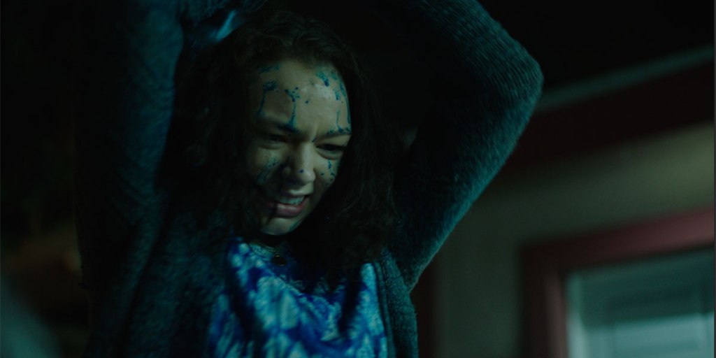 A girl with a blue liquid splattered on her face.