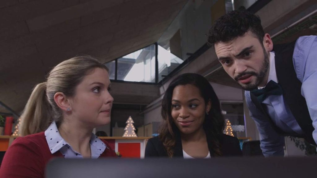 Amber (Rose McIver) and her friends and colleagues Melissa (Tahirah Sharif) and Andy (Joel McVeagh) looking at a computer screen.