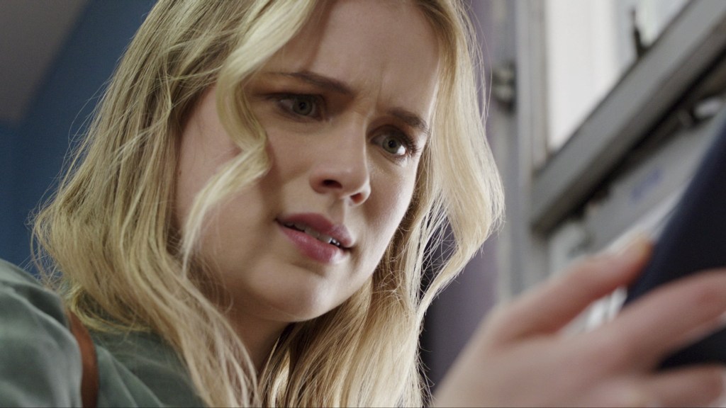 Quinn (Elizabeth Lail) staring at her phone.