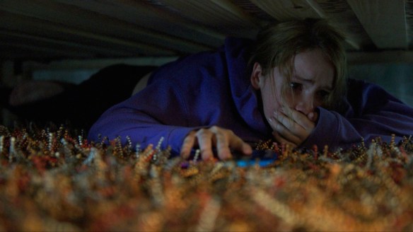Jordan (Talitha Eliana Bateman) hiding under the bed.