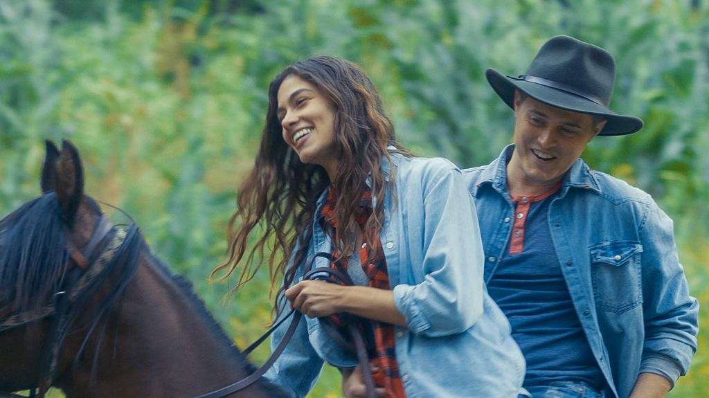 Jo (Sarah Davenport) and Laurie (Lucas Grabeel) on a horse.