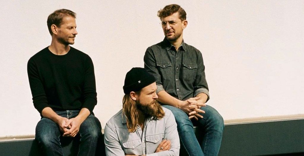 A photo of the band consisting of three white men.