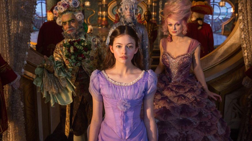A young girl (Mackenzie Foy) surrounded by dressed up people.