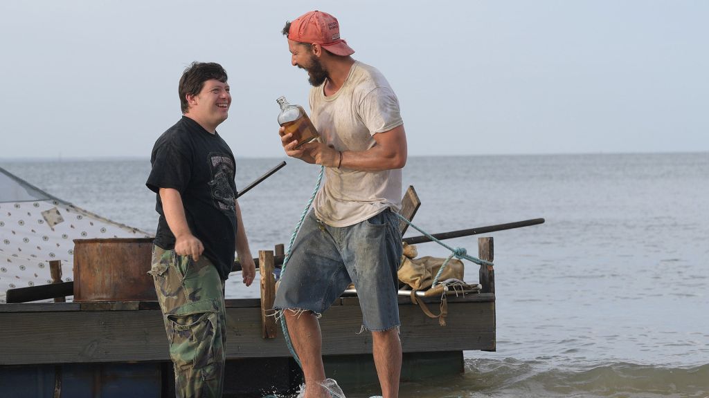 Zak (Zack Gottsagen) and Tyler (Shia LaBeouf) getting drunk on a beach.