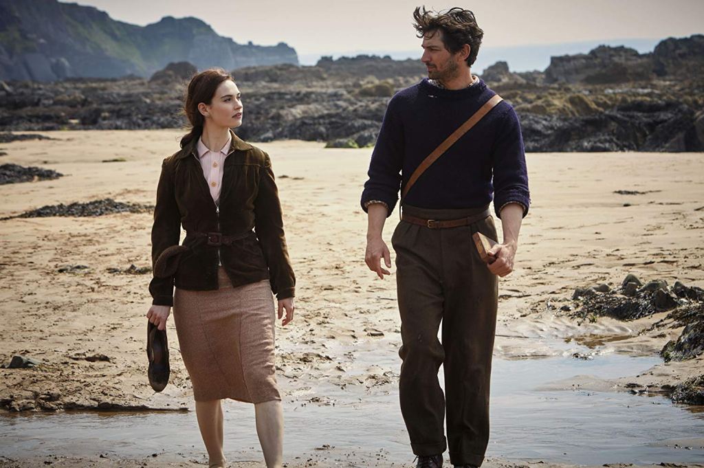 Juliet Ashton (Lily James) and Dawsey Adams (Michiel Huisman) taking a walk on the beach. 