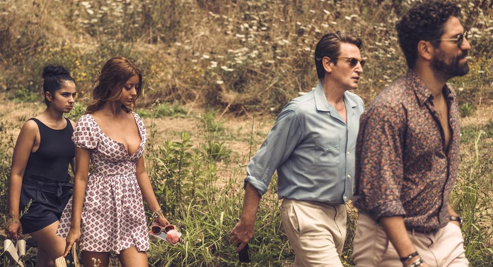 Sofia (Zahia Dehar) and Naïma (Mina Farid) walking behind Philippe (Benoît Magimel) and Andres (Nuno Lopes). 