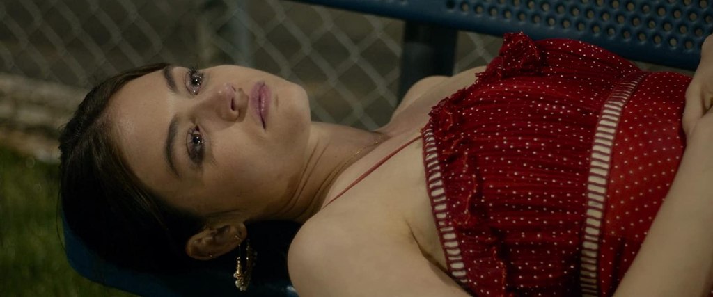 Lily (Lucy Hale) lying on a bench. 