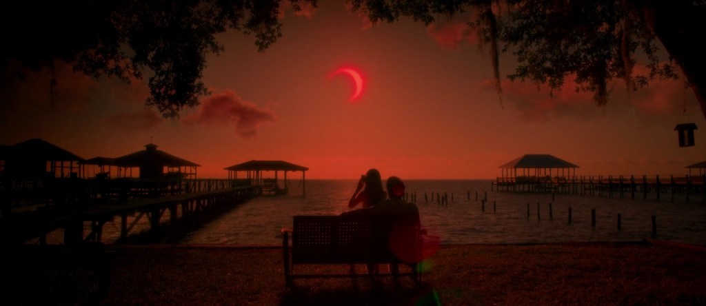 Jessie (Chiara Aurelia) and her father (Henry Thomas) watch a solar eclipse.