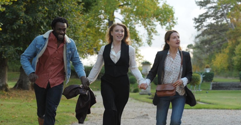 Simone (Sarah Stern) walking hand-in-hand with Wali (Jean-Christophe Folly) and Claire (Julia Piaton).