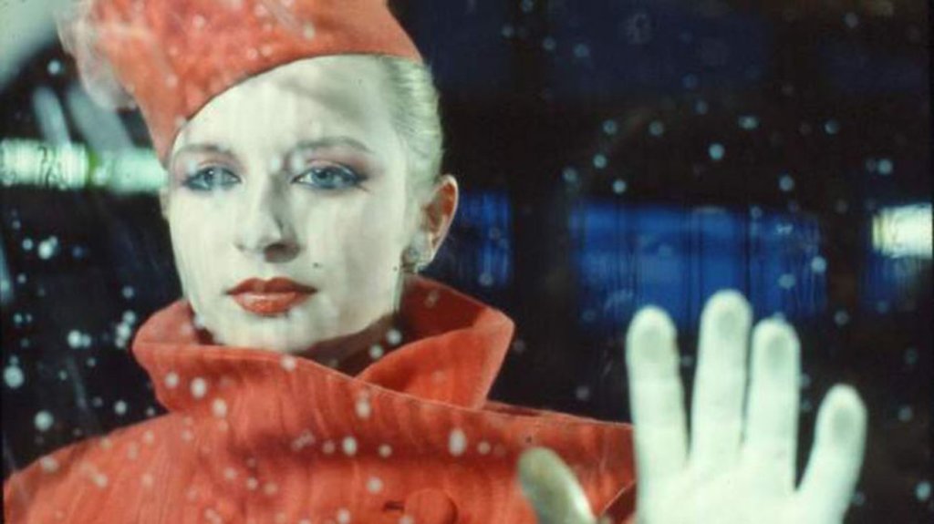 The protagonist (Tabea Blumenschein) standing behind a galss window that is being cleaned.