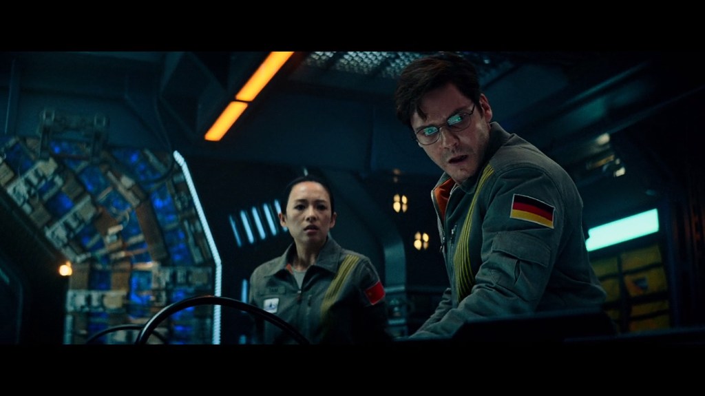 Tam (Ziyi Zhang) and Schmidt (Daniel Brühl) looking at the machines on the spacecraft.