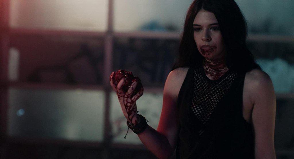 Laurel (Nicole Maines) with a bloody mouth and a bloody heart in her hands.