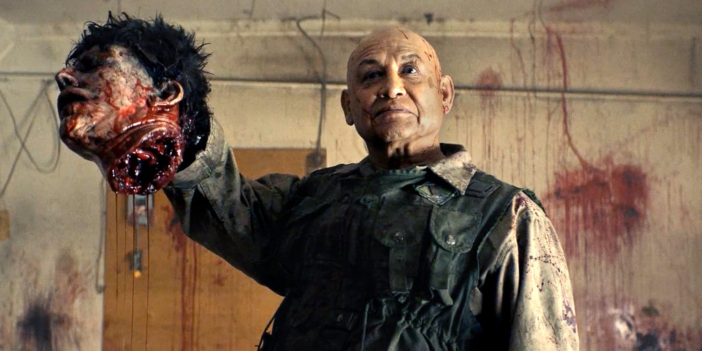 Gisigu (Stonehorse Lone Goeman) holding up a severed head. 