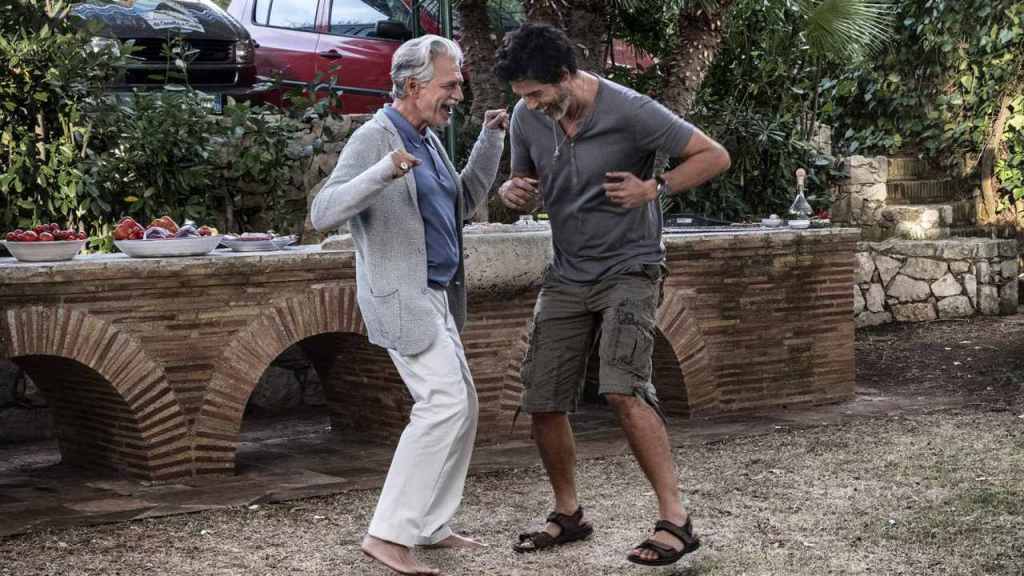 Carlo (Alessandro Gassmann) and Tony (Fabrizio Bentivoglio) dancing together.