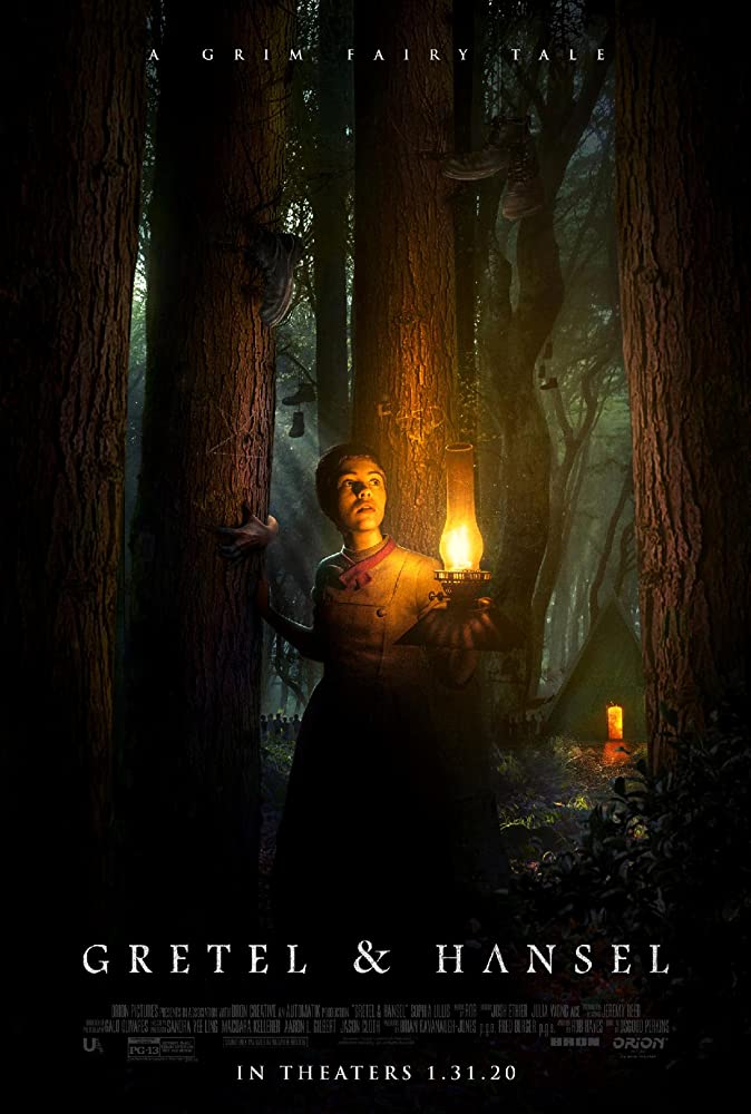 The film poster showing Gretel (Sophie Lillis) walking through the woods with an oil lamp. Shoes are hanging from the trees and a cabin can be seen in the back.