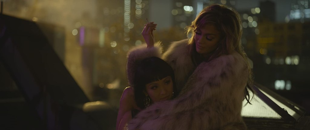 Ramona (Jennifer Lopez) wrapping Destiny (Constance Wu) into her fur coat while wearing it herself.