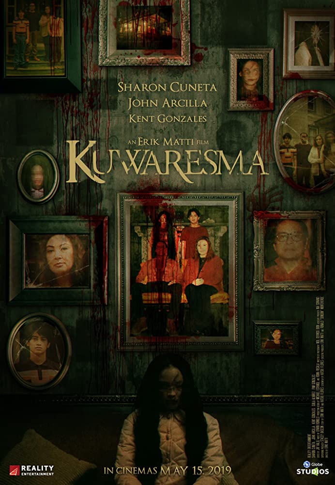 The film poster showing a wall full of family portraits, splattered in blood, a ghost girl sitting in front of it.