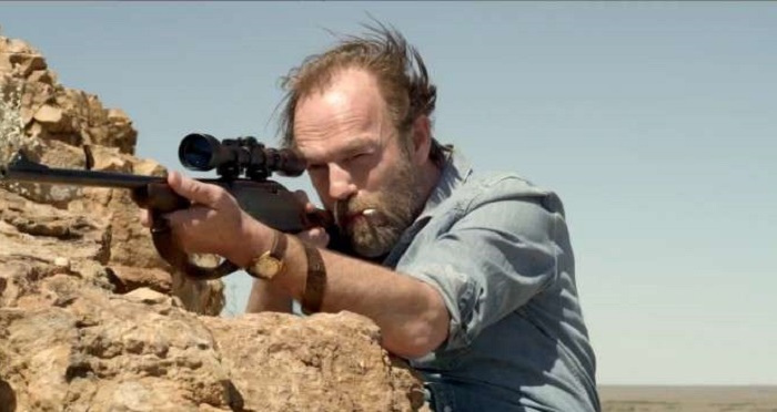 Johno (Hugo Weaving) aiming his gun.