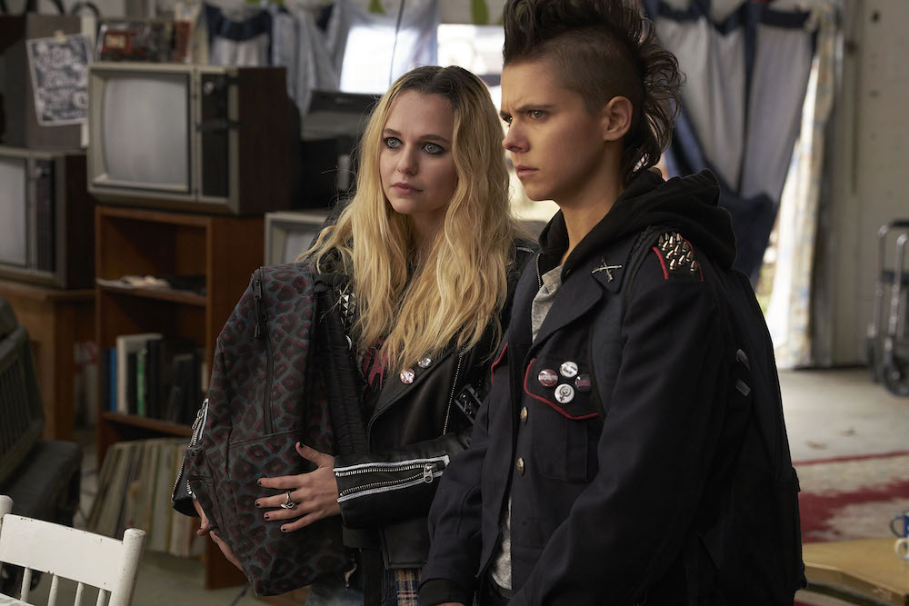 Scratch (Paloma Kwiatkowski) and Nat (Madison Iseman) carrying a backpack. 