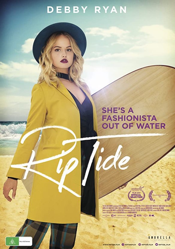The film poster showing Cora (Debby Ryan) in fashionable clothes with a surfboard in her hand.