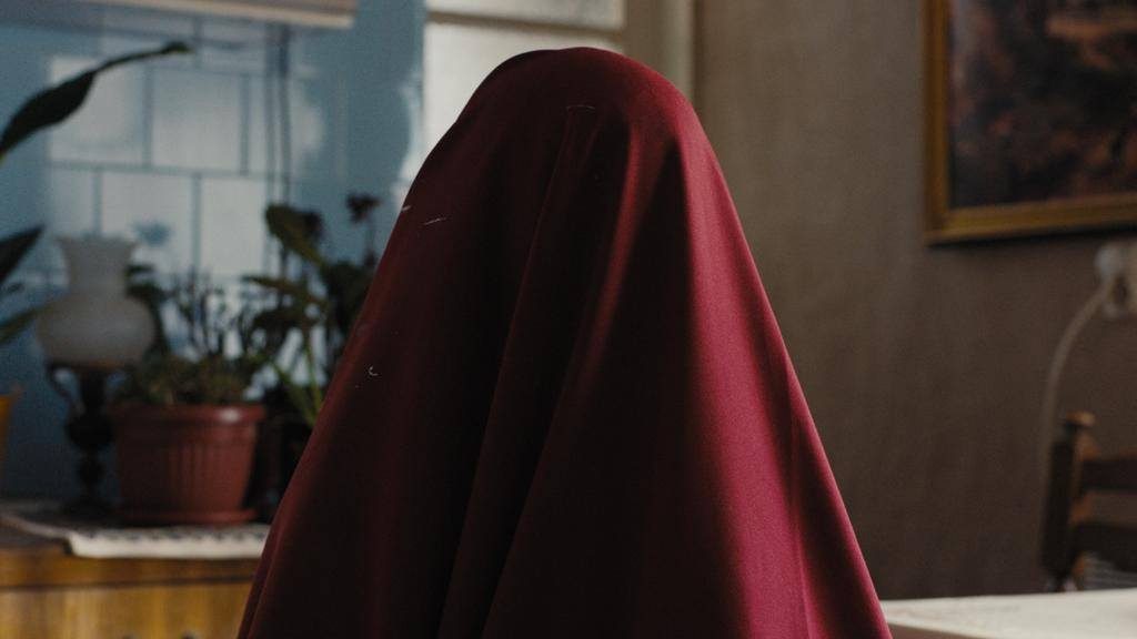 A human shape covered by a red blanket.