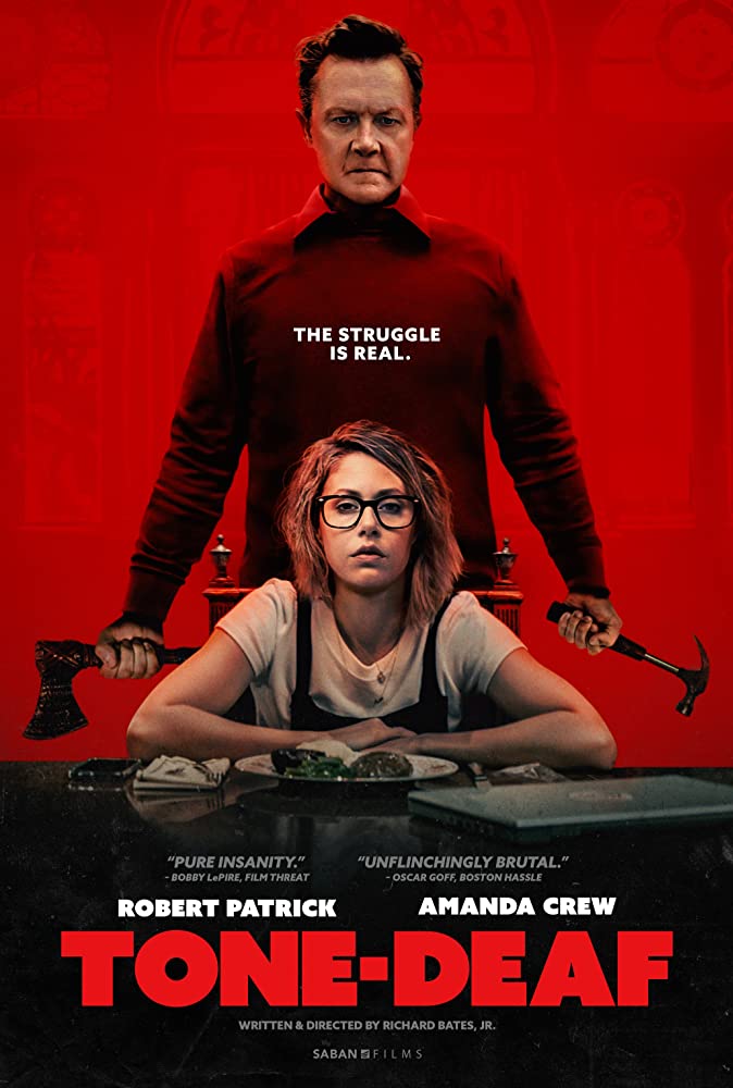 The film poster showing Olive (Amanda Crew) sitting at a table with Harvey (Robert Patrick) standing behind her, an axe in one hand a hammer in the other.