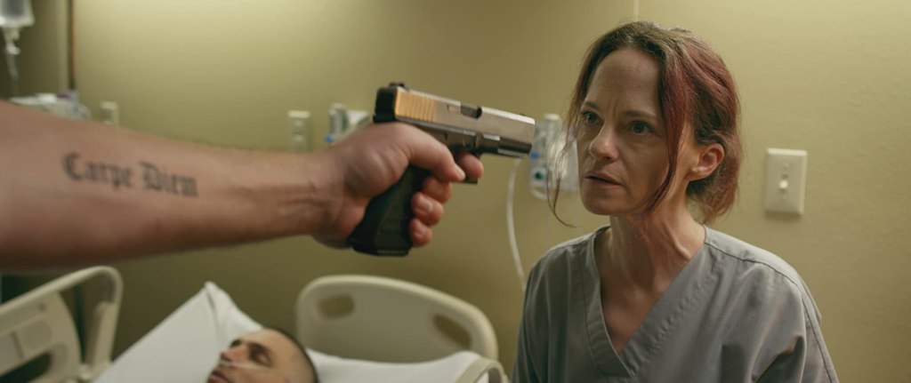 Mandy (Angela Bettis) with a gun pointed at her face.