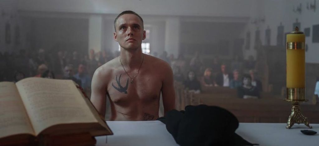 Daniel (Bartosz Bielenia) standing half-naked in front of the altar.