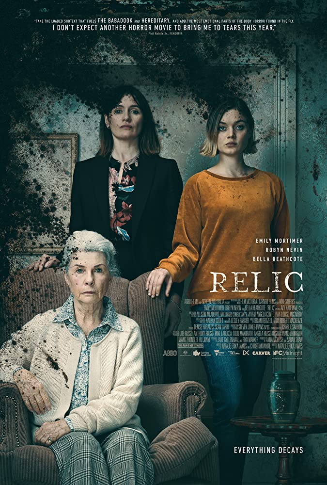 The film poster showing Edna (Robyn Nevin), Kay (Emily Mortimer) and Sam (Bella Heathcote) standing like a family portrait. Black mold is in the corner of the picture.