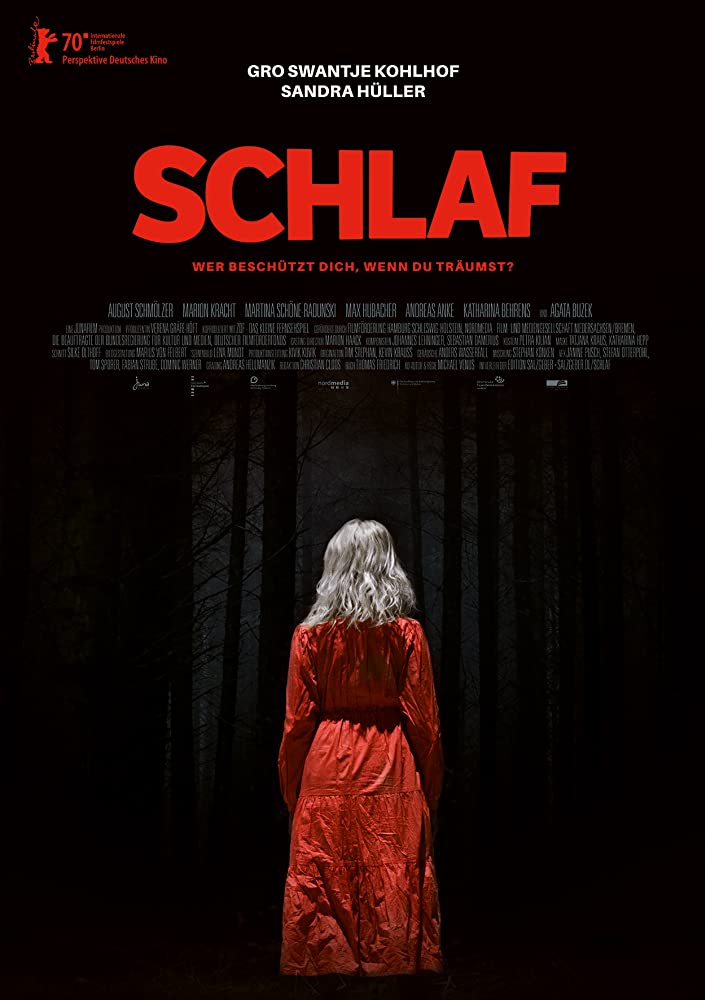 The film poster showing a blond woman in a red dress with her back to the camera in a forest so dark, it's almost entirely black. 