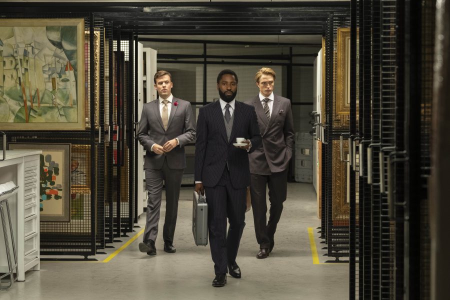The Protagonist (John David Washington) walking through a vault with his partner Neil (Robert Pattinson). 