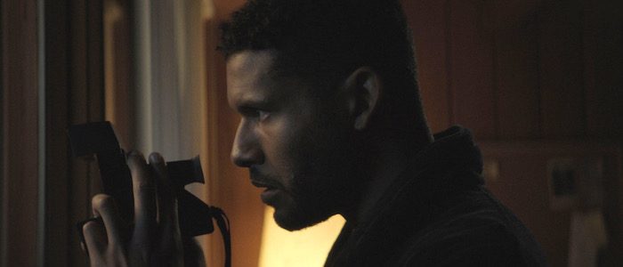 Malik (Jeffrey Bowyer-Chapman) taking a polaroid picture of the neighbors through his window.