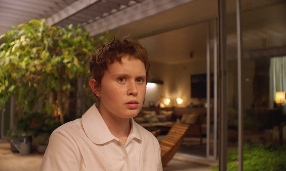 Milla (Eliza Scanlen) with her hair cut short in a wild way, looking sceptical. 