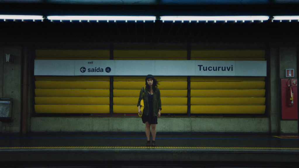 Laura (Clara Kinzo) alone in a subway station. 