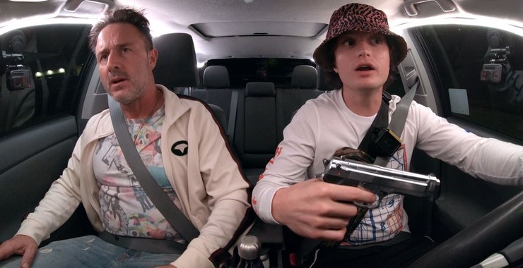 Kurt (Joe Keery) driving his father Kris (David Arquette). Kurt has a gun in his hand. 