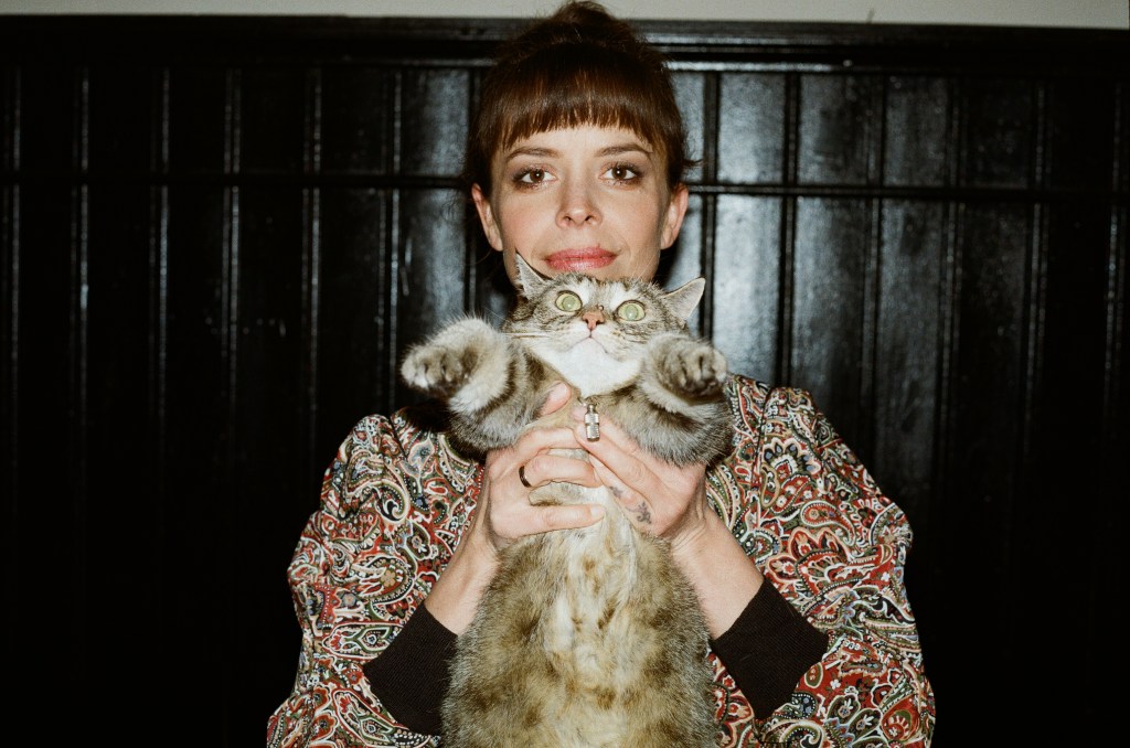 Clara Luzia holding up a cat.