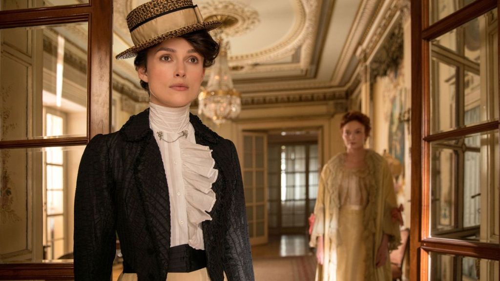 Colette (Keira Knightley) standing in a doorway, Georgie Raoul-Duval (Eleanor Tomlinosn) in the background. 