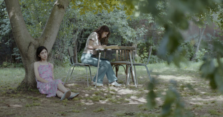 Teenaged Nana (Mariam Iremashvili) and Irina (Nina Mazodier) in the garden together. 
