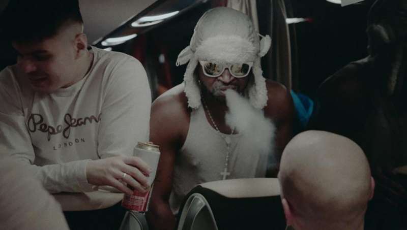 Two of Robin's players smoking and drinking on a bus.