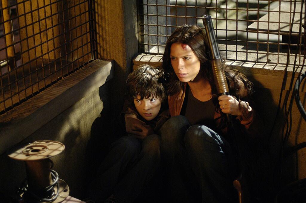 Rachel (Rhona Mitra) cowering in a cage with her son Timothy (Matthew Knight).