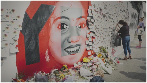A mural of Savita Halappanavar surrounded by lots of messages on paper.