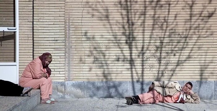 Two women sitting and lying in the sun.